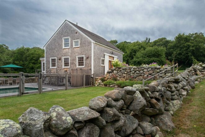 Exterior of a Guest Cottage Beach House in Martha's Vineyard overlooking the pool with traditional weathered Cedar siding